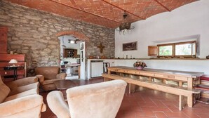 Un intérieur rustique avec des murs en pierre, un banc en bois et un coin cuisine.