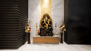 A statue of a deity in a temple setting with marble walls and a dark floor. - Ramee Techome (Mumbai)