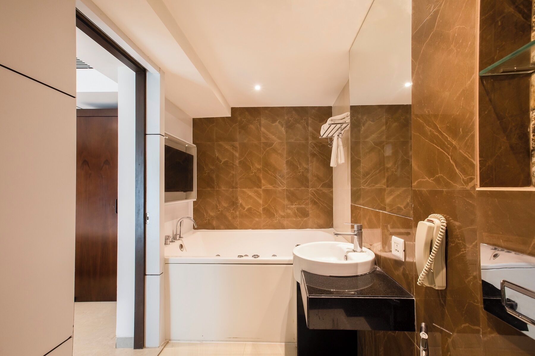 A modern bathroom with a bathtub, a sink, and a mirror.