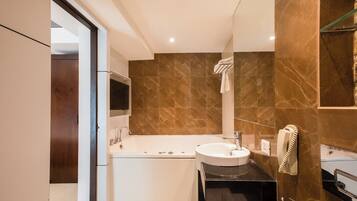 Un baño moderno con bañera, lavabo y espejo.