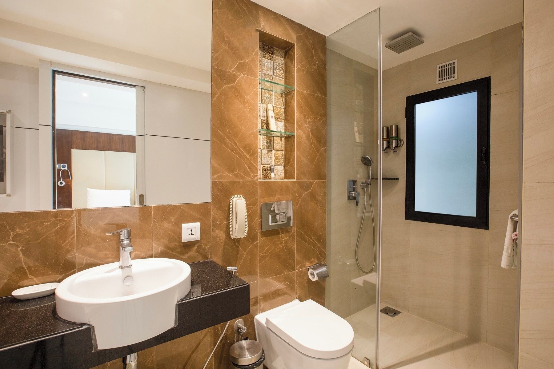 A modern bathroom with a glass-enclosed shower, a sink, and a toilet.