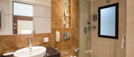 A modern bathroom with a glass-enclosed shower, a sink, and a toilet.