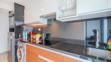 A modern kitchen with a built-in washer, stainless steel appliances, and a dishwasher.