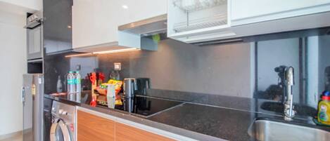 A modern kitchen with a built-in washer, stainless steel appliances, and a dishwasher.