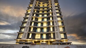 A multi-story hotel with balconies, large windows, and outdoor seating areas. - Ramee Techome (Mumbai)