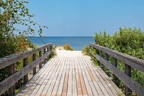 A wooden boardwalk leading to a beach with clear blue water. - Apartment beach life. 2 bedrooms, high quality furnishings, great sea views! (Börgerende-Rethwisch)