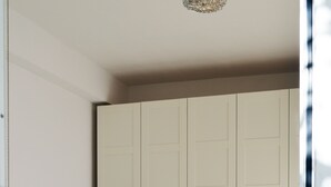 Un dormitorio con cama de madera, armario blanco y una escalera en la pared.