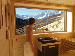 A sauna room with a large window offering a view of snow-capped mountains. - Vacation rental in the Ötztal with sauna – vacation at an organic & horse farm (Umhausen)
