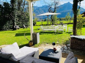 Un patio con mobiliario exterior, una pérgola y vistas a montañas.