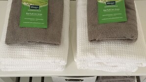 Two folded towels with labels on a white shelf. - Farmhouse from 1869 with modern ambience, free WLAN, oven and large garden (Dahlem- Berk)