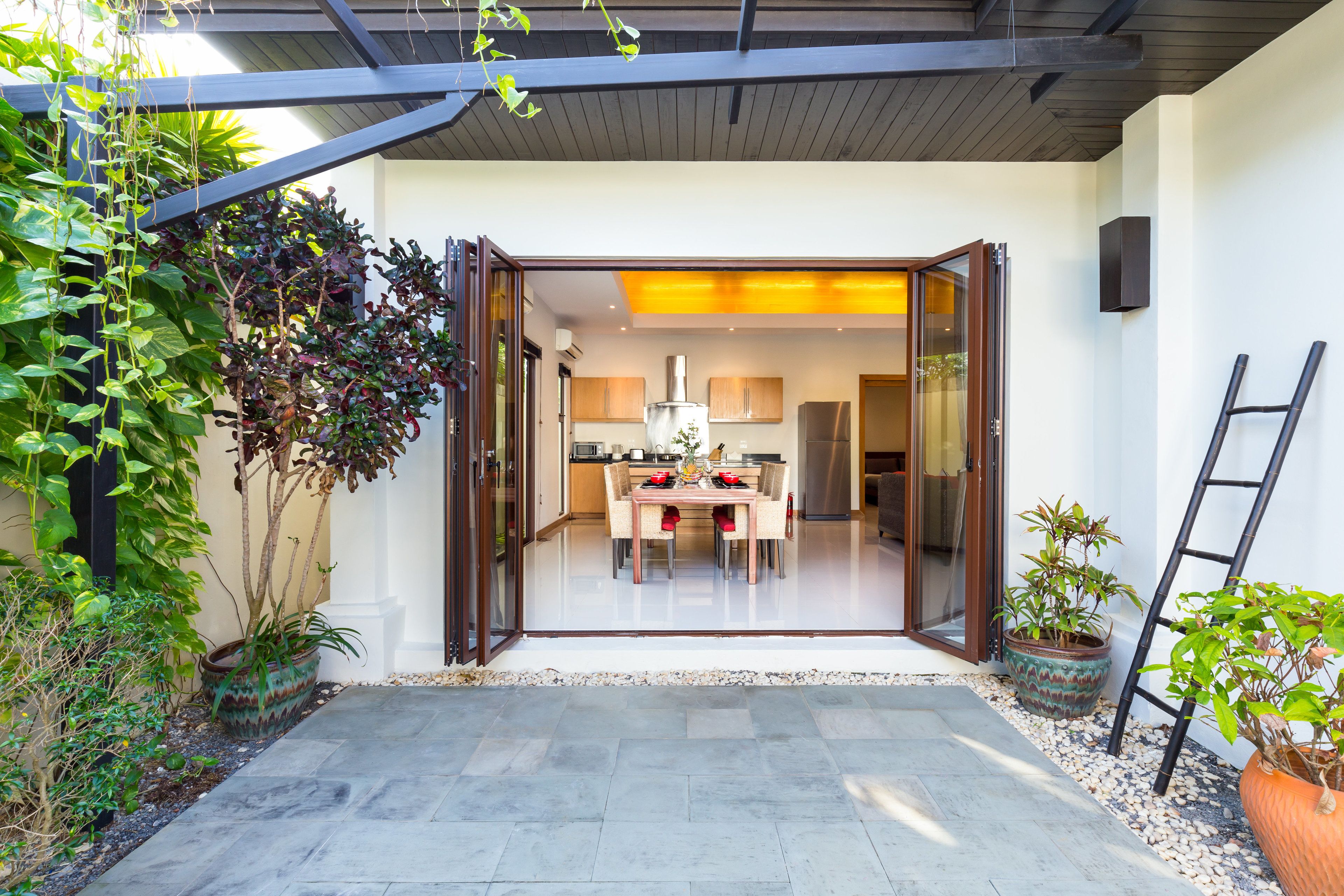A modern house with a dining area, kitchen, and a covered patio.