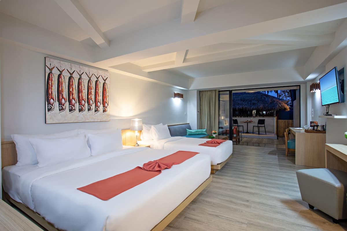 Een hotelkamer met twee bedden, een bureau, een televisie en een zithoek met uitzicht.