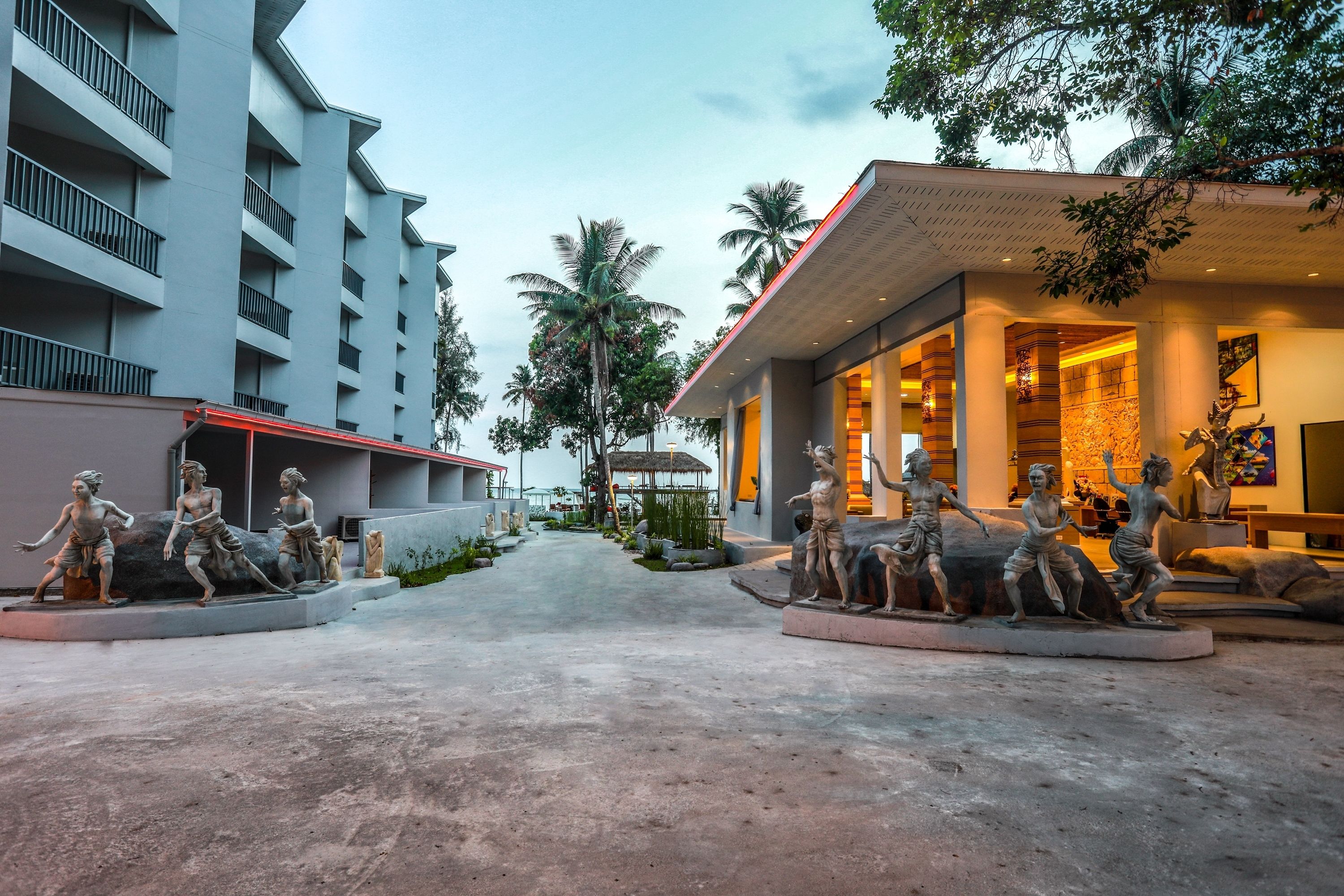 A modern hotel with a central courtyard featuring a statue of a group of figures.