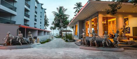 A modern hotel with a central courtyard featuring a statue of a group of figures.