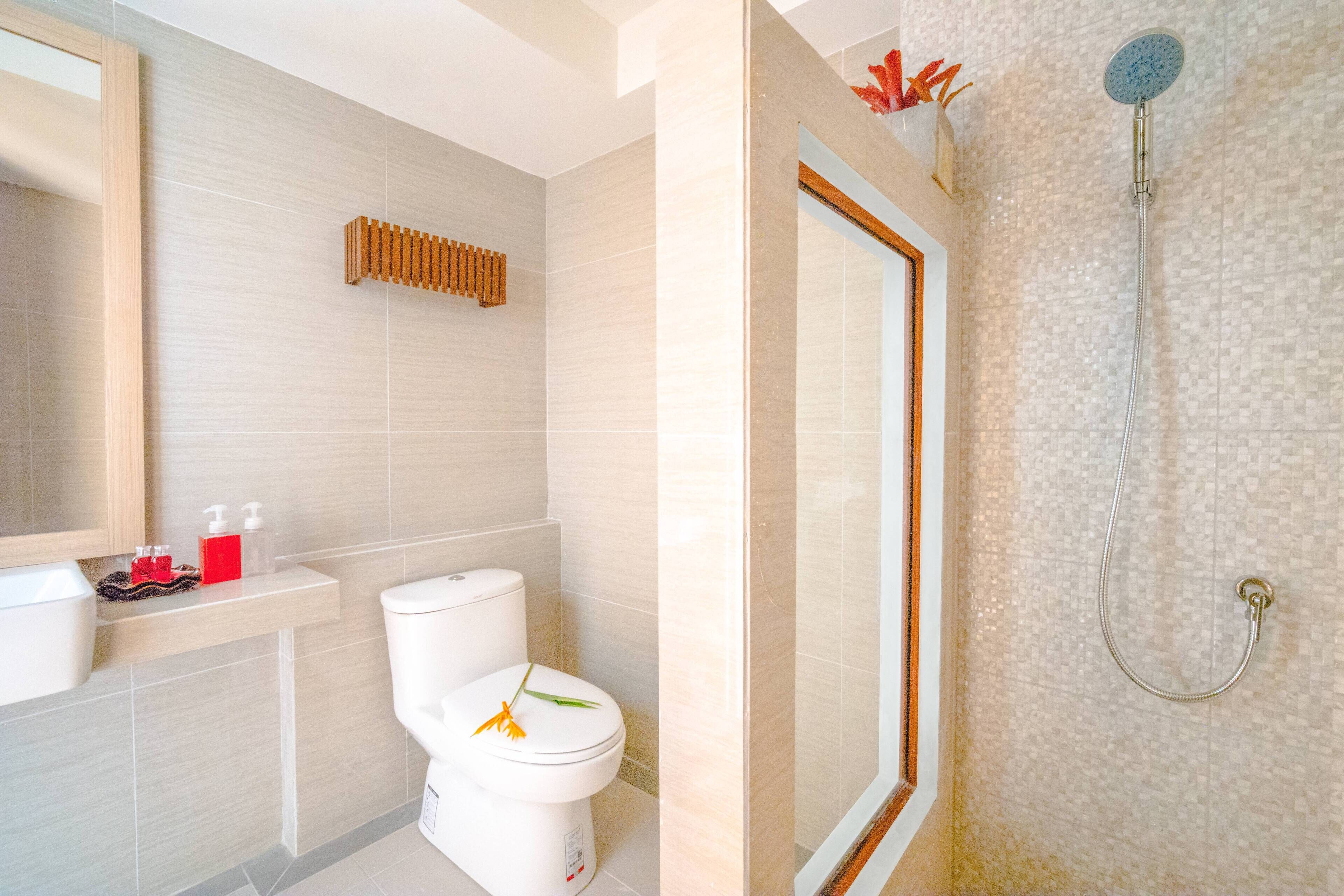 Un baño moderno con inodoro, lavamanos y ducha.