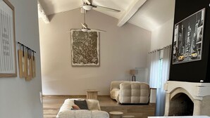 Una sala de estar moderna con chimenea, un conjunto de sofás y un comedor con bancos.