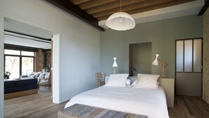 Un dormitorio con una cama grande, cabecera de madera y una lámpara colgante.