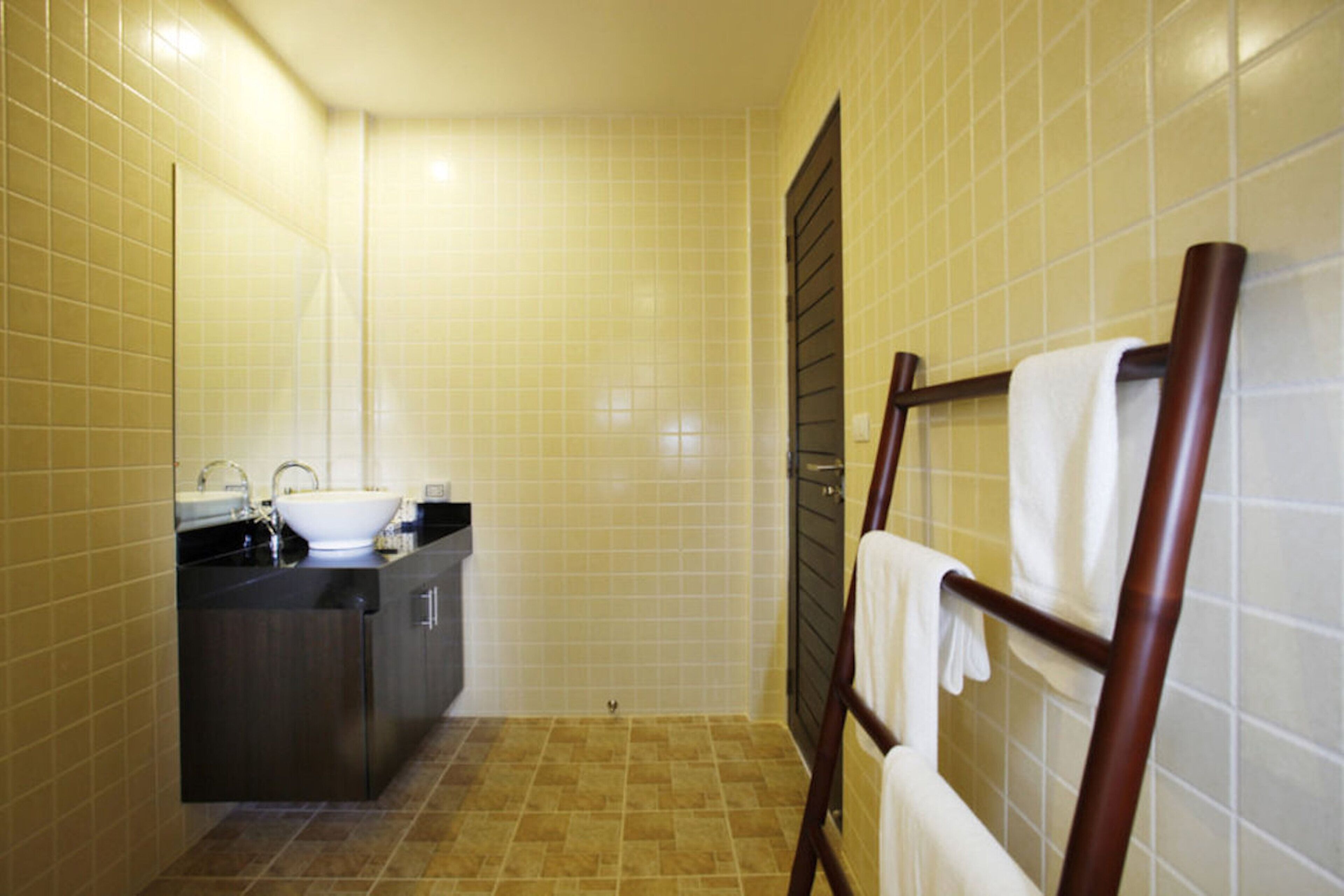 Ein Badezimmer mit Waschbecken, Spiegel und Handtuchhalter.