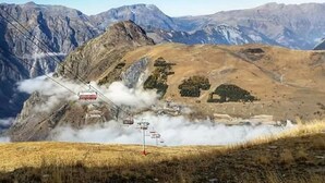 A cable car system in a mountainous area with a clear sky.