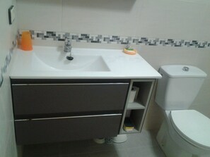 Ein Badezimmer mit Waschbecken, Toilette und einem Spiegelschrank.