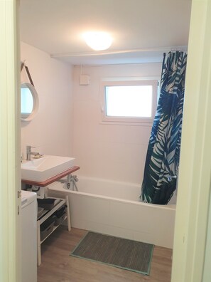 Bathtub, hair dryer, towels, toilet paper