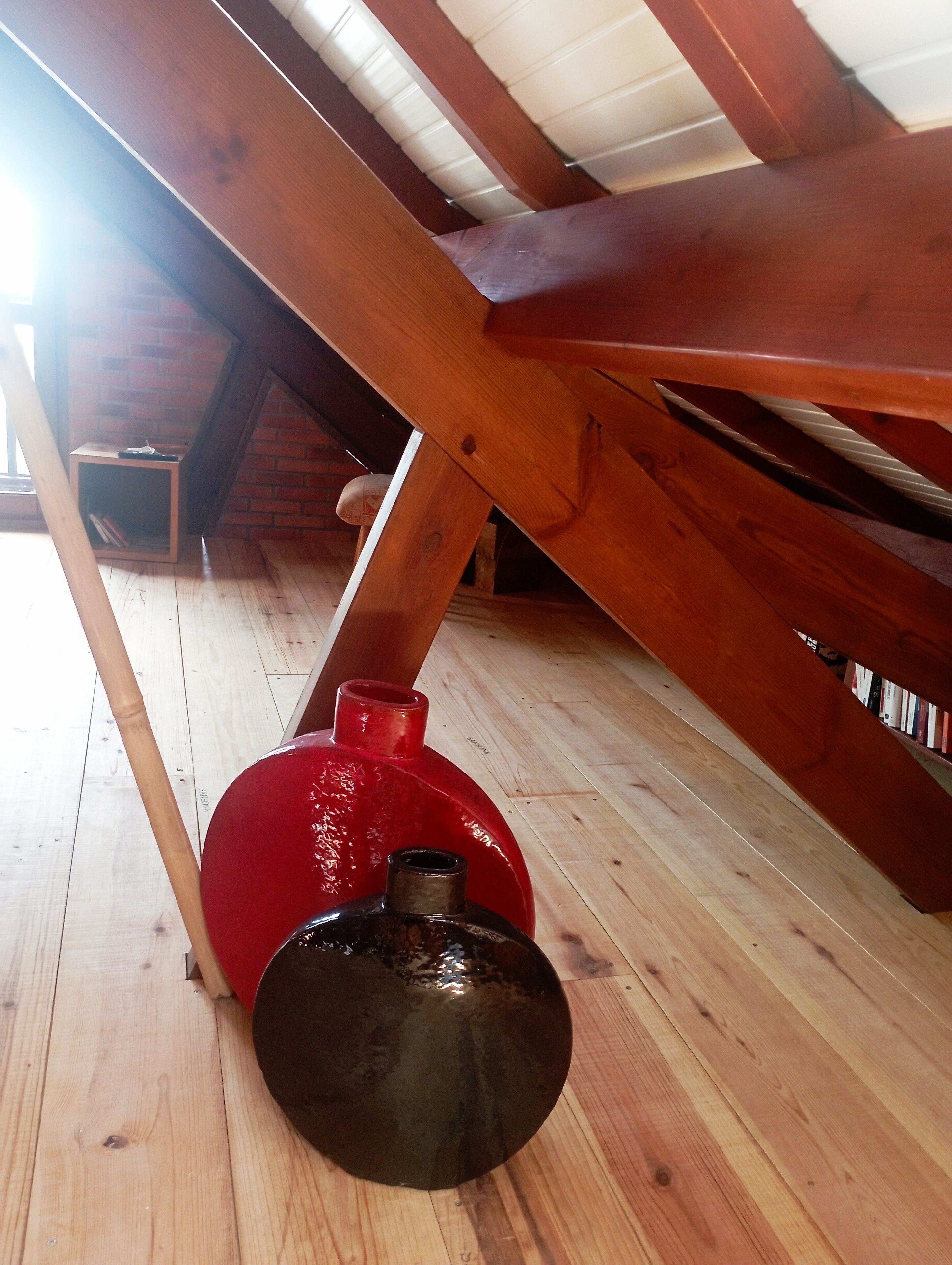 A wooden ceiling structure with a red object and a black object on the floor.