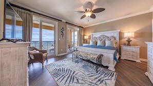 A bedroom with a large bed, a ceiling fan, a view of the ocean, and a balcony. - 4 BR En Soleil Directly on Gulf, 14th floor unit with the best views!! (Panama City Beach)