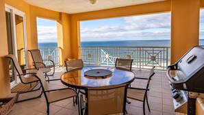 A balcony with a round table, chairs, and a grill. - 4 BR En Soleil Directly on Gulf, 14th floor unit with the best views!! (Panama City Beach)