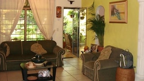 A living room with two sofas, a coffee table, and a potted plant. - Vacation Home: the Space, Privacy, Comfort of Your Own House! (San Salvador)
