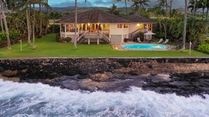 A beachfront property with a swimming pool, a covered patio, and a view of the ocean. - Honu Lani | Private Oceanfront Home + Pool, Elevated Views & A/C (Koloa)