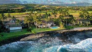A coastal property with a swimming pool, multiple houses, and palm trees. - Honu Lani | Private Oceanfront Home + Pool, Elevated Views & A/C (Koloa)