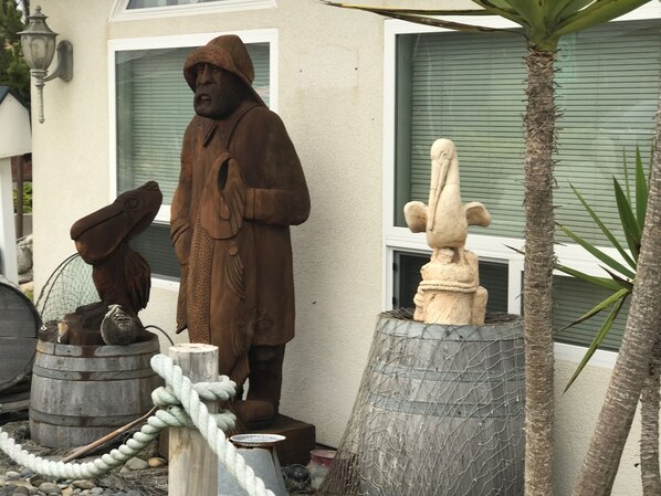 A statue of a man in a long coat standing next to a stone sculpture of a bird. - Captain Java's Cottage in beautiful Morro Bay! (Morro Bay)
