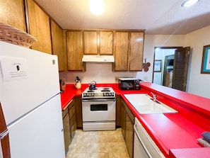 Enjoy cooking in this well-equipped kitchen with a stove, microwave, and sink.