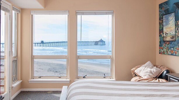 A bedroom with a large window overlooking a beach and pier. - San Diego County Oceanfront 3 bedroom-heated pool/jacuzzi. Complex on the sand (Imperial Beach)