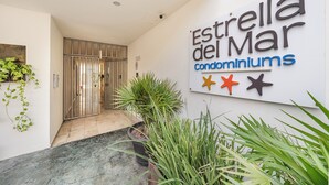 Señalización para los condominios Estrella del Mar, con una reja de metal y plantas en macetas.