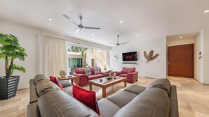 Una sala de estar moderna con sofás de cuero, una mesa de centro y un televisor en la pared.