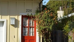A house with a red door, number 226, and a small porch with potted plants. - Sweet 1 BDRM Cottage, FAST WIFI, near ocean, W&D, Full kitchen and bath, BBQ! (Santa Cruz)
