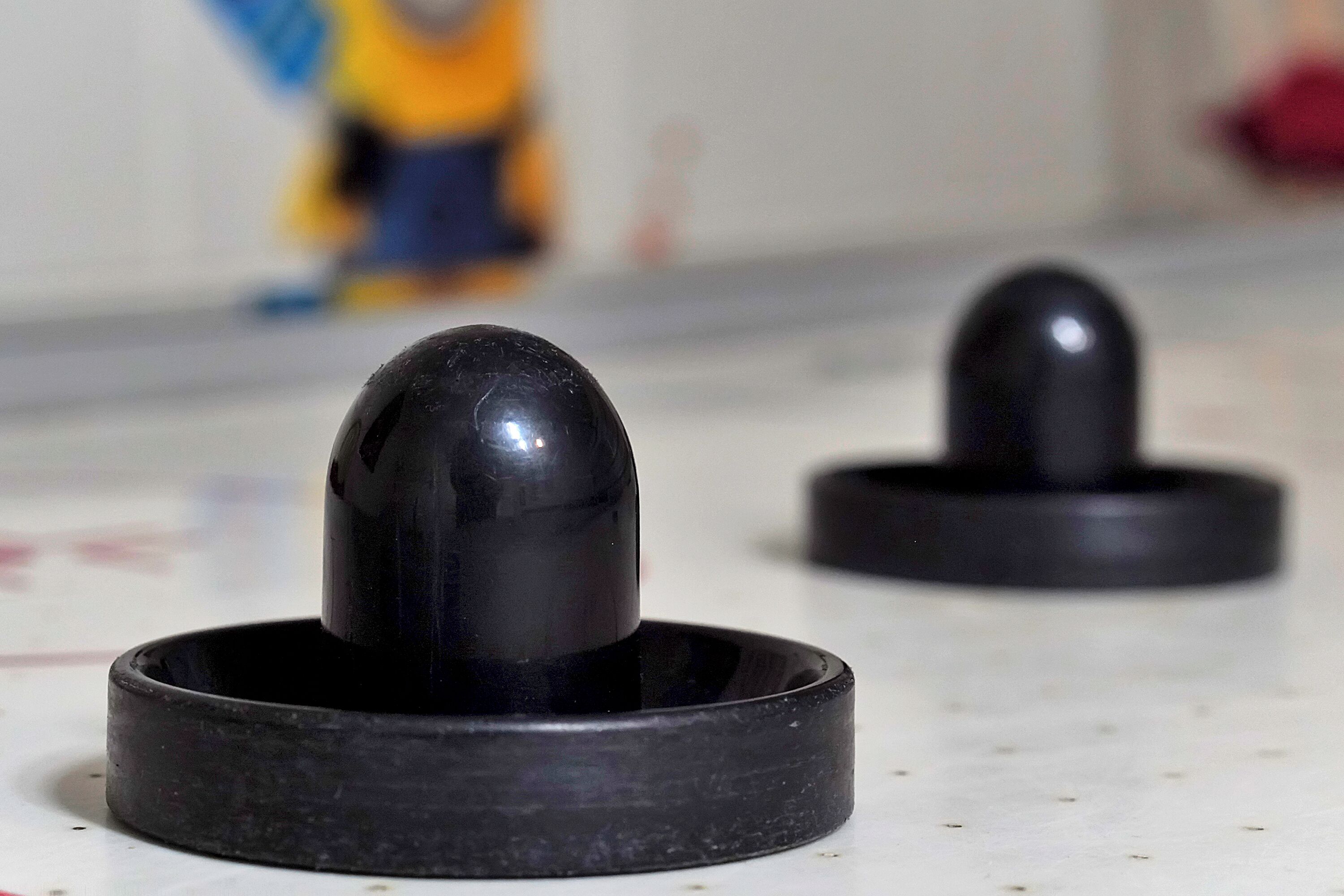 Two black cylindrical objects on a white surface.