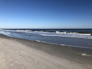 Ein Strand mit klarem Himmel und Wellen.