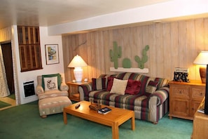 Relax in this inviting living room with a striped sofa, wooden coffee table, and armchair.