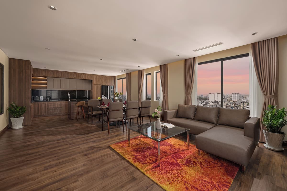 A modern living room with a sofa, coffee table, and dining area.