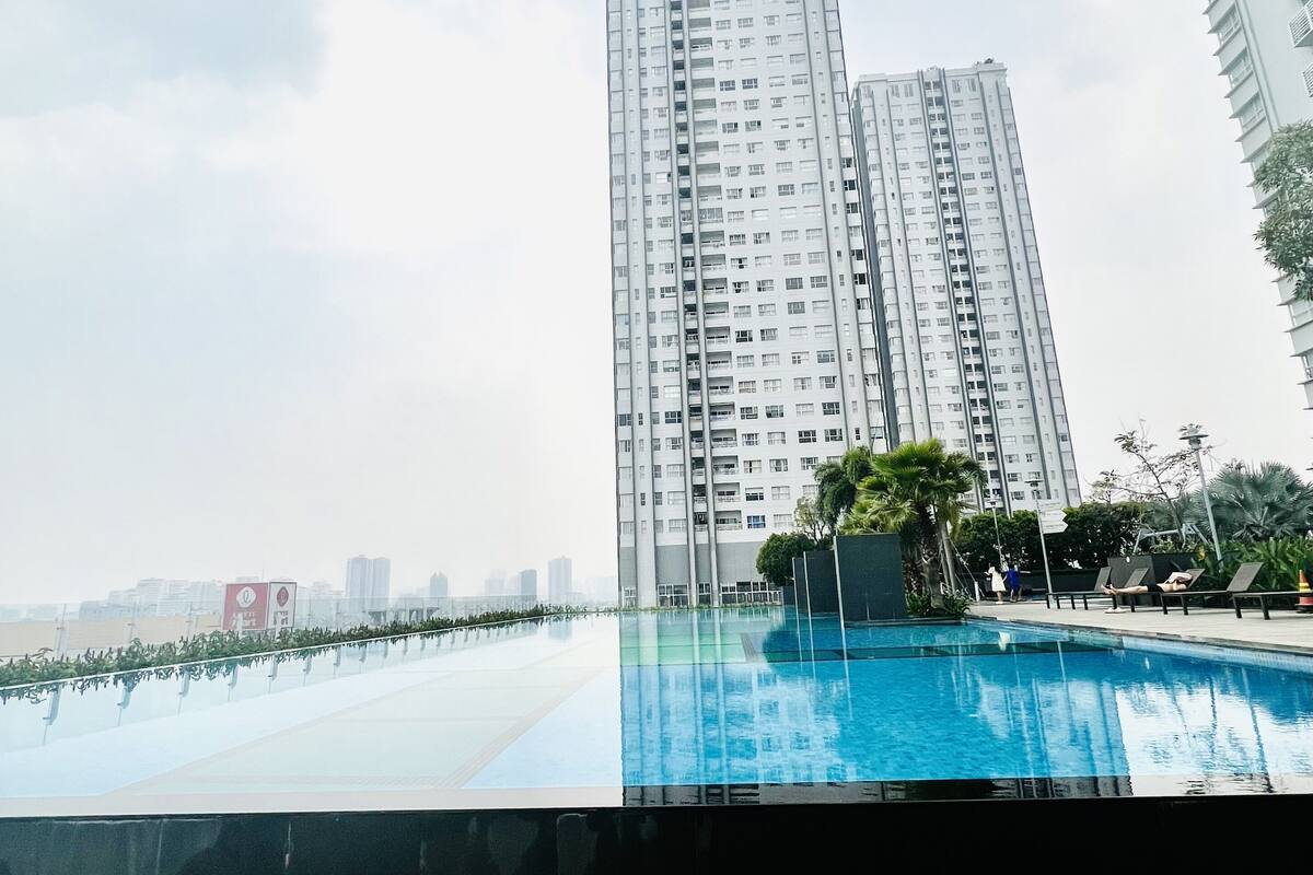 Ein Hochhaus mit einem Pool im Vordergrund.