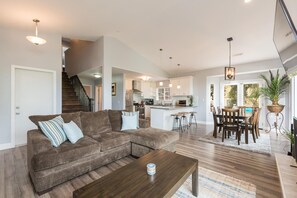 Relax in a spacious living area with a plush sofa, dining table, and modern kitchen.