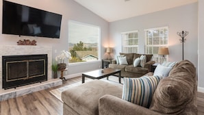 A living room with a fireplace, a flat-screen TV, a sofa, and a coffee table. - Fabulous 4 Bed/3 Bath Rental on Lodge Hill! Updated, Charming & Pet-Friendly! (Cambria)