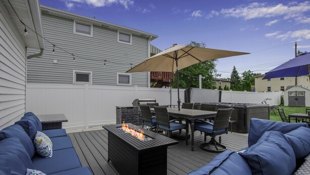 A covered outdoor patio with a fire feature, seating, and a table. - Spacious/Comfy/Private Home near Buffalo/Bills/Airport/Niagara Falls (Depew)