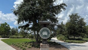 Señal del Refugio Nacional de Vida Silvestre Lowcountry, con un camino pavimentado y abundante vegetación.