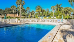 A swimming pool with a white fence, lounge chairs, and palm trees in the background. - Condo with Private Beach Access, Great Shared Amenities - Private Beach House (Siesta Key)