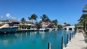 A marina with boats docked, a bridge, and palm trees. - DUPLEX IN DUCK KEY, 2 Bedroom/2 Bath, W/Private 90' Dock,  Trailer Storage (Duck Key)