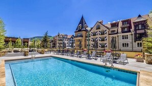 A swimming pool with lounge chairs and a view of colorful buildings.
