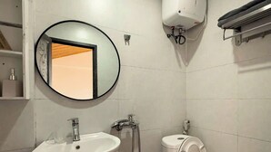 Ein Badezimmer mit Waschbecken, Toilette und Wandluftreiniger.